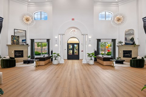 A large, open-concept living space with a fireplace, couches, and a large arched doorway.