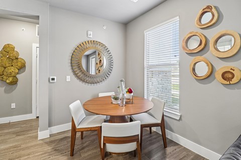 A dining room with a round table and chairs.