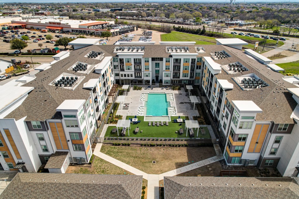 an aerial view of a building with a pool in the middle