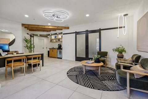 A modern living room with a black and white rug and a wooden coffee table.
