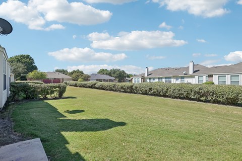 A grassy area with a building in the background.