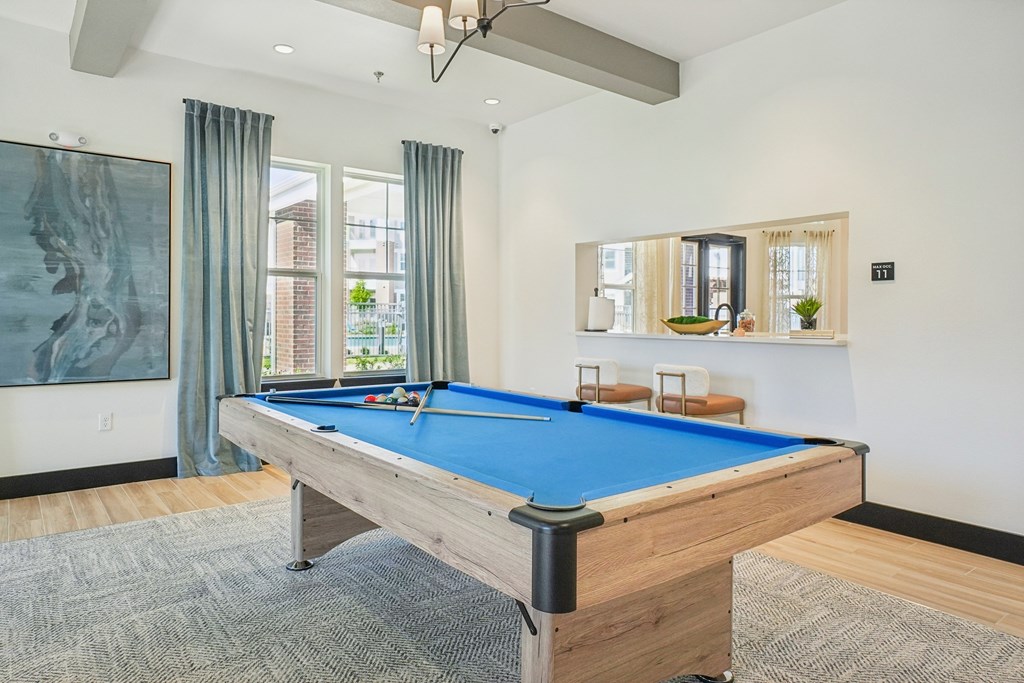 A pool table in a room with a painting on the wall.
