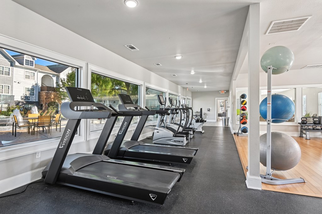 A gym with treadmills and a large ball.