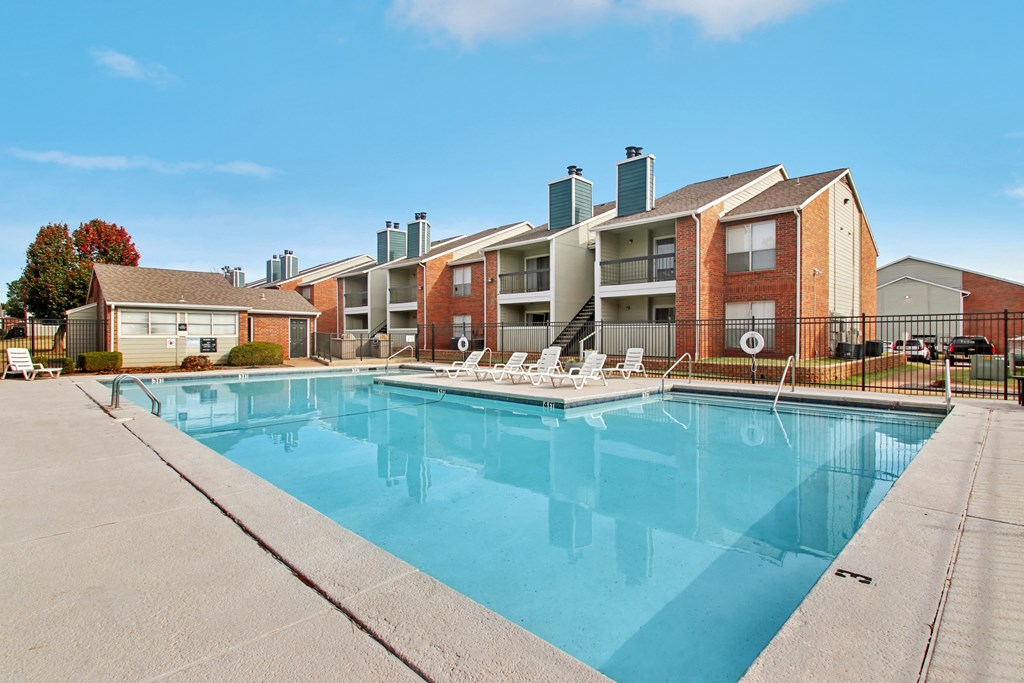 A large swimming pool in front of apartment buildings.