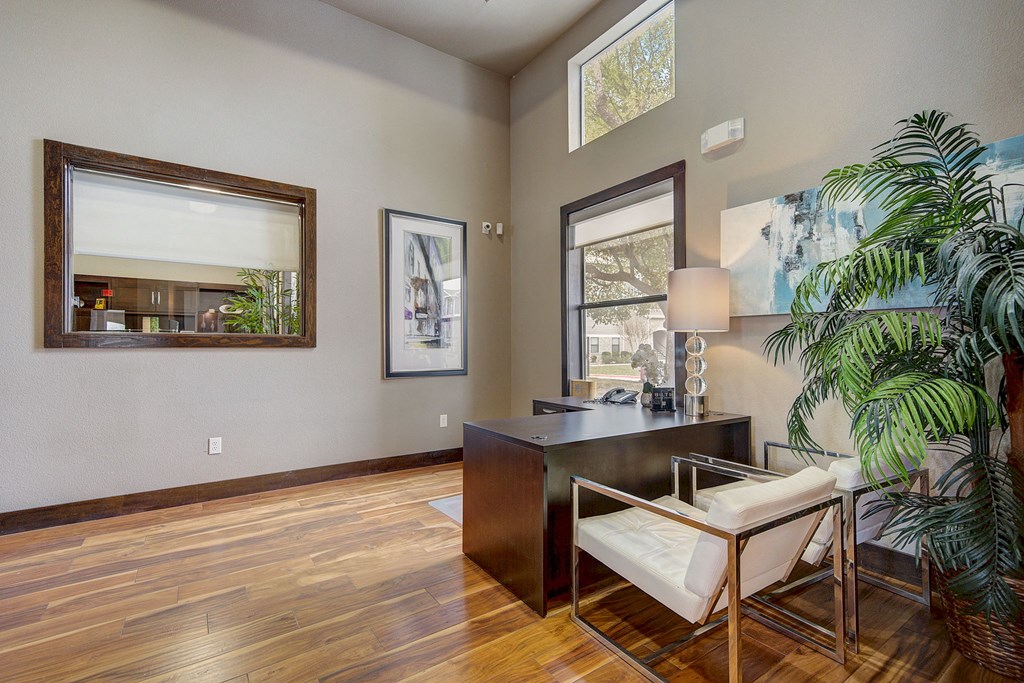 a living room with a desk and a plant