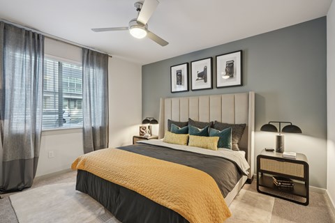 A bedroom with a bed, nightstand, and a ceiling fan.