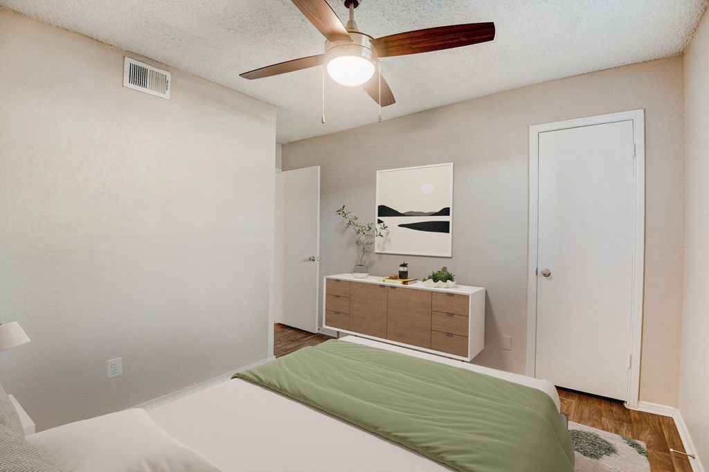 a bedroom with a bed and a ceiling fan