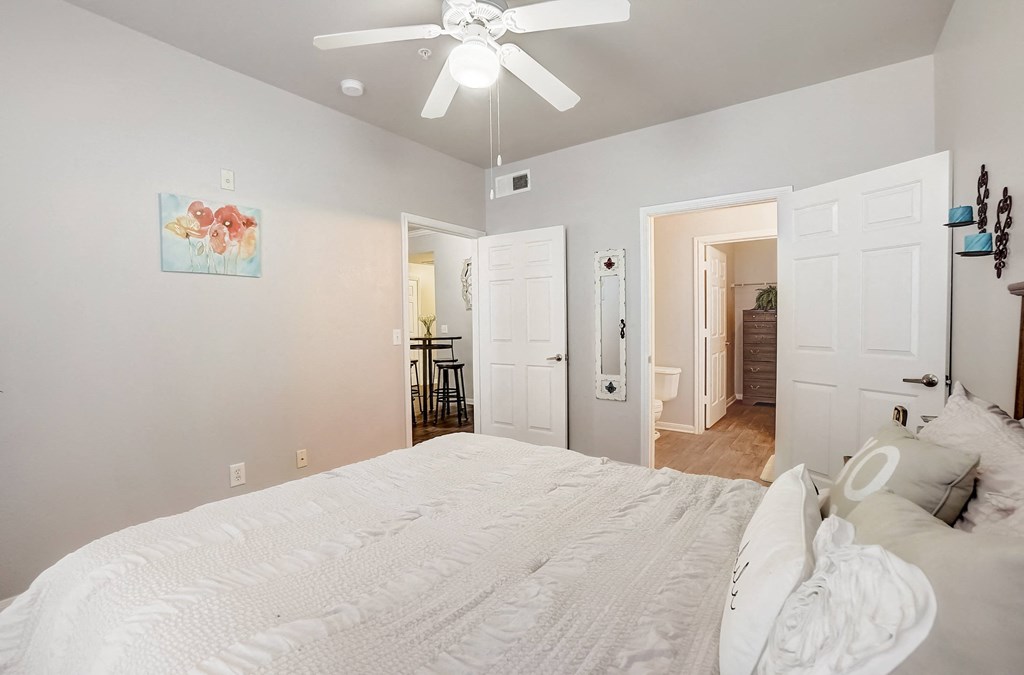a bedroom with a large bed and a ceiling fan