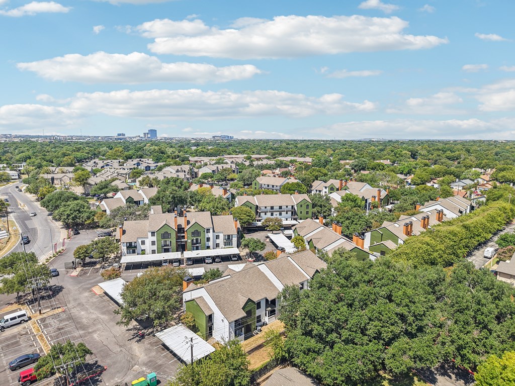 A bird's eye view of a small town with a parking lot in the foreground.