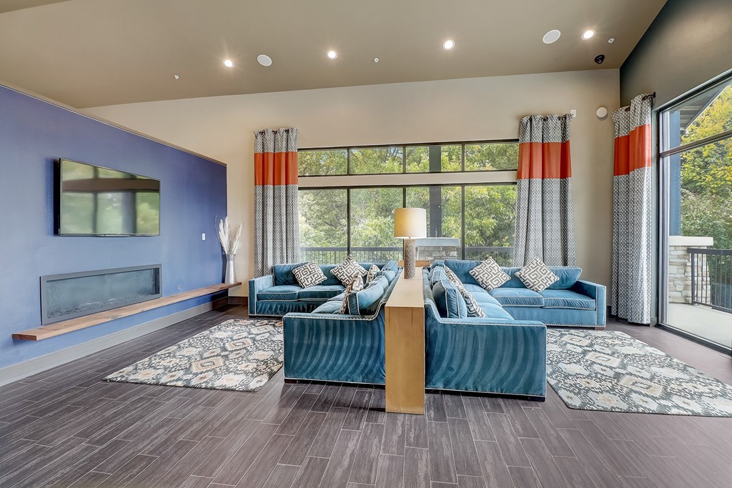 a living room with blue couches and a large window