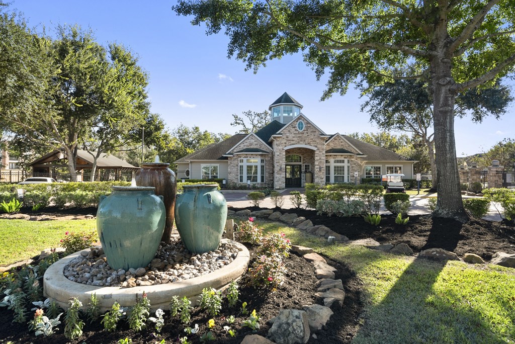the front yard of a house with two vases in the garden