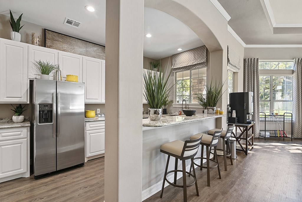 a kitchen with stainless steel appliances and a bar with stools