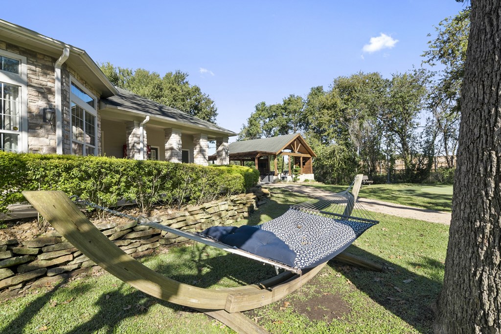 a swinging chair in the yard of a house