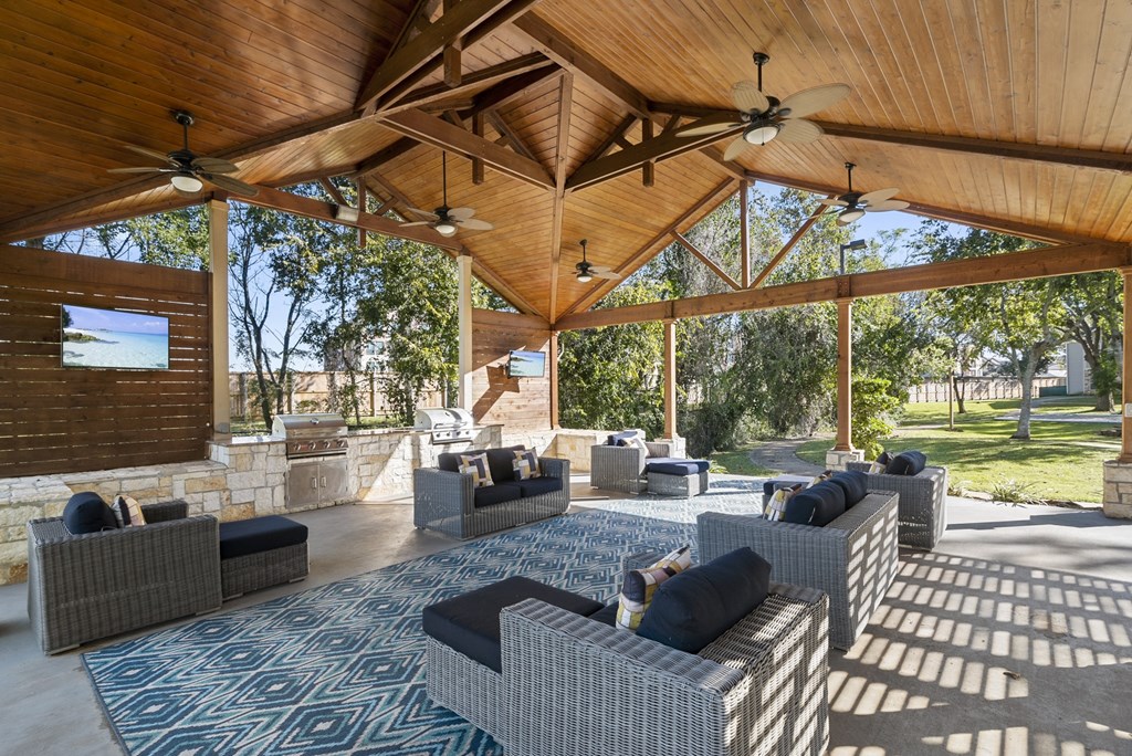 a patio with couches and chairs and a tv