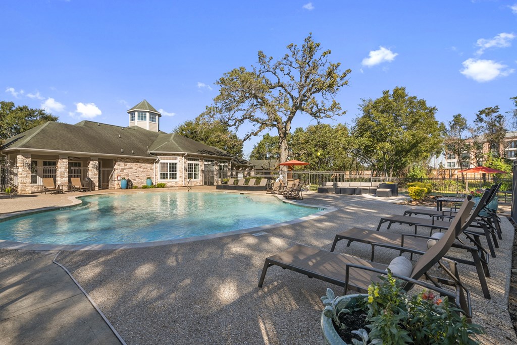 a pool with chairs and a building in the background
