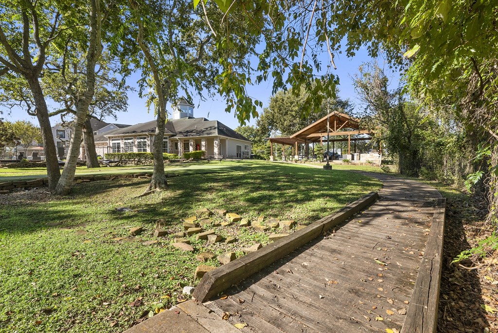 a path through a park with a house in the background