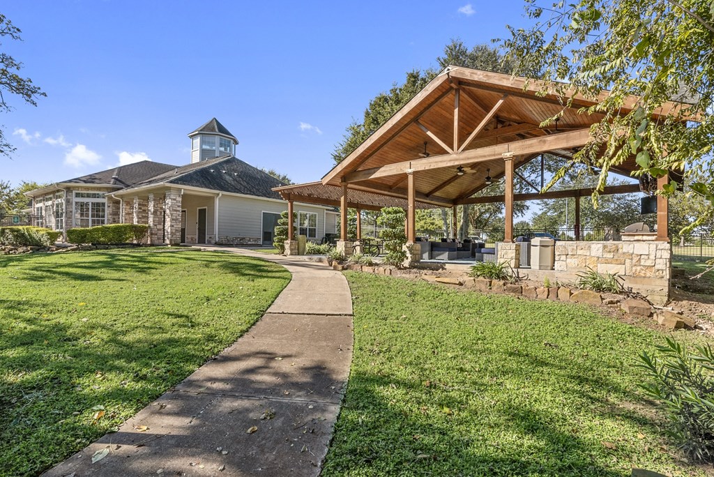 a walkway leading to a house with a pavilion