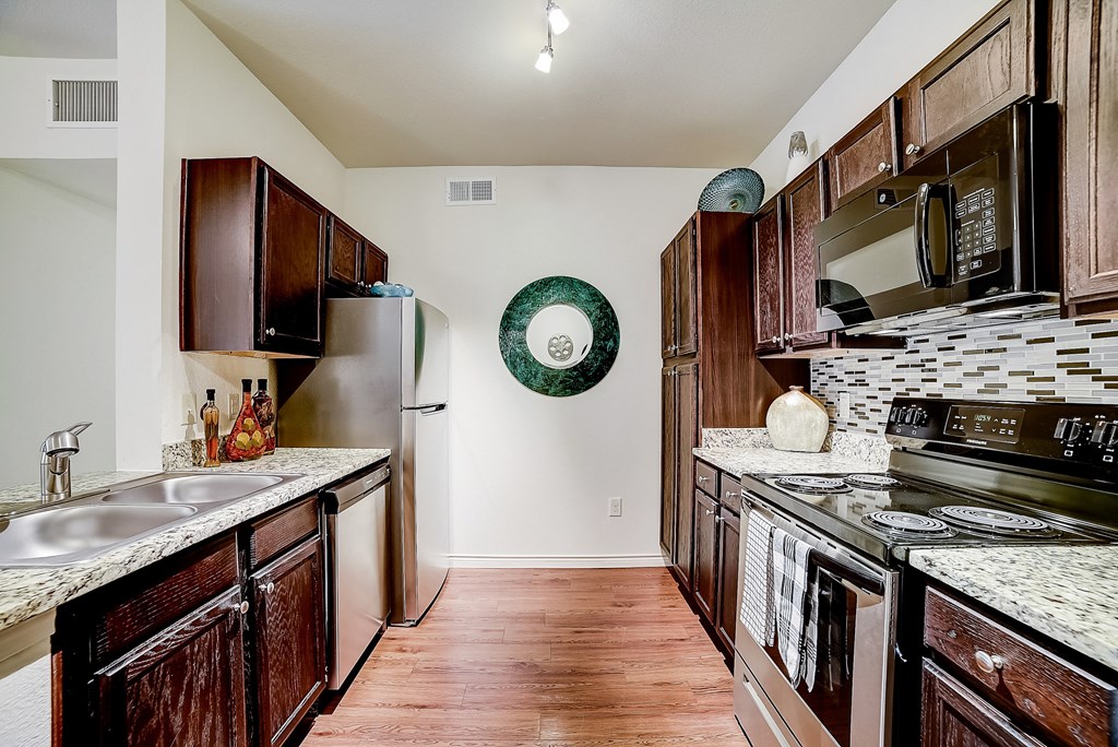 a kitchen with dark wood cabinets and white countertops