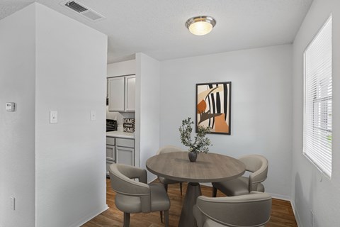 A dining room with a table and chairs.