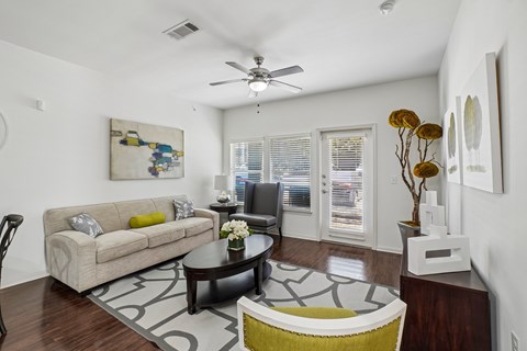 A living room with a couch, coffee table, and a painting on the wall.