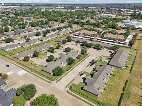 A bird's eye view of a residential area with houses and a parking lot.