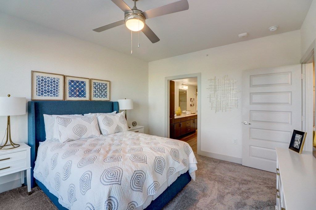 a bedroom with a large bed and a ceiling fan
