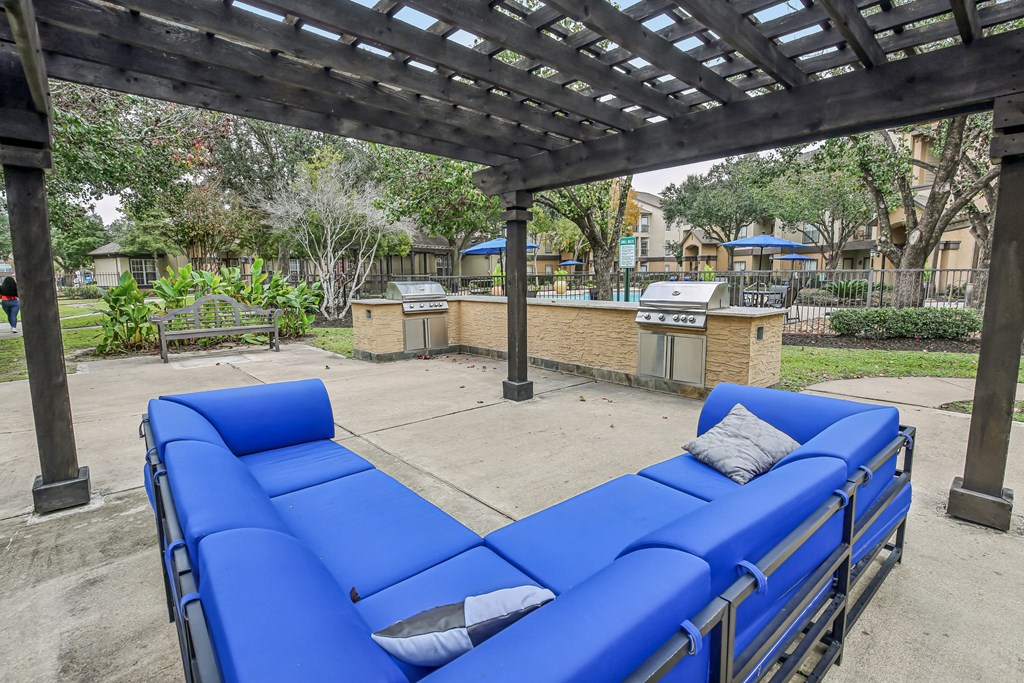A blue lounge chair under a wooden pergola.