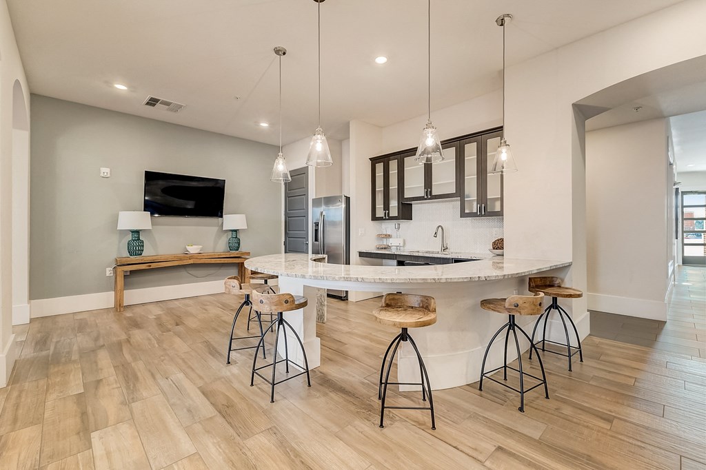 an open kitchen and living room with a bar and stools
