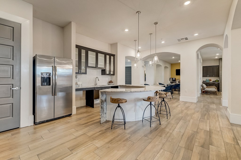 a kitchen with stainless steel appliances and a large island with bar stools
