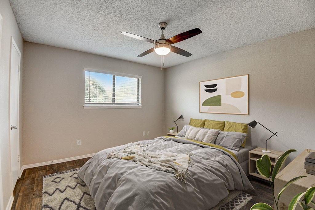a bedroom with a large bed and a ceiling fan