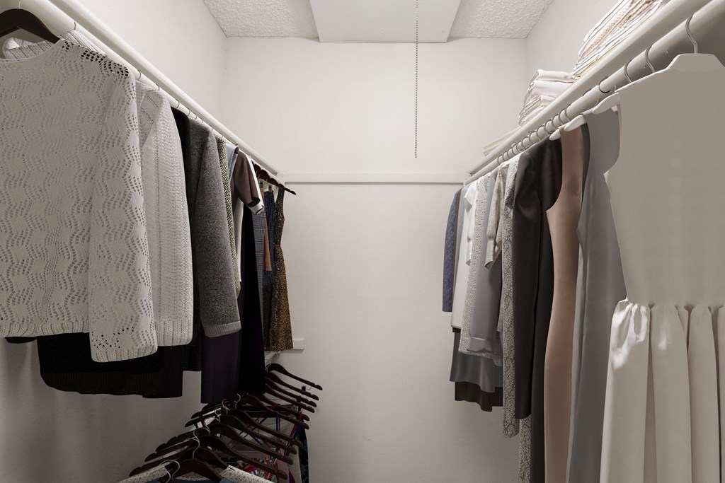 a walk in closet filled with clothes and shoes