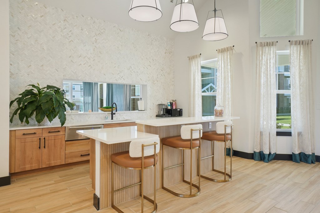 A kitchen with a white counter and bar stools.