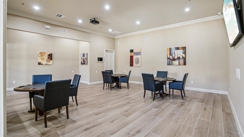 A room with a dining table and chairs.