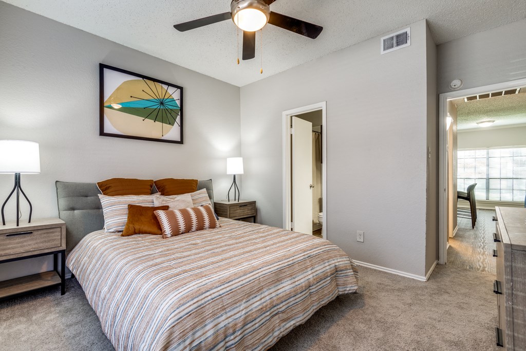 the master bedroom has a large bed and a ceiling fan