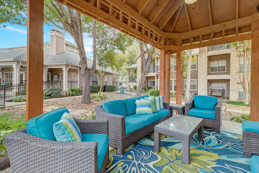 a covered patio with couches and chairs and a table