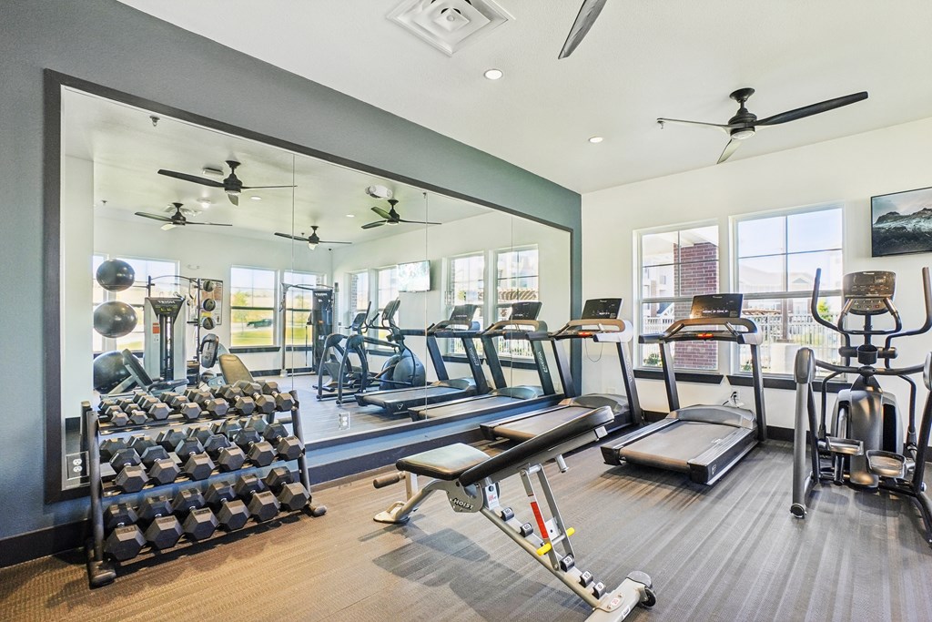 A spacious gym with a variety of equipment including treadmills, weights, and exercise machines.