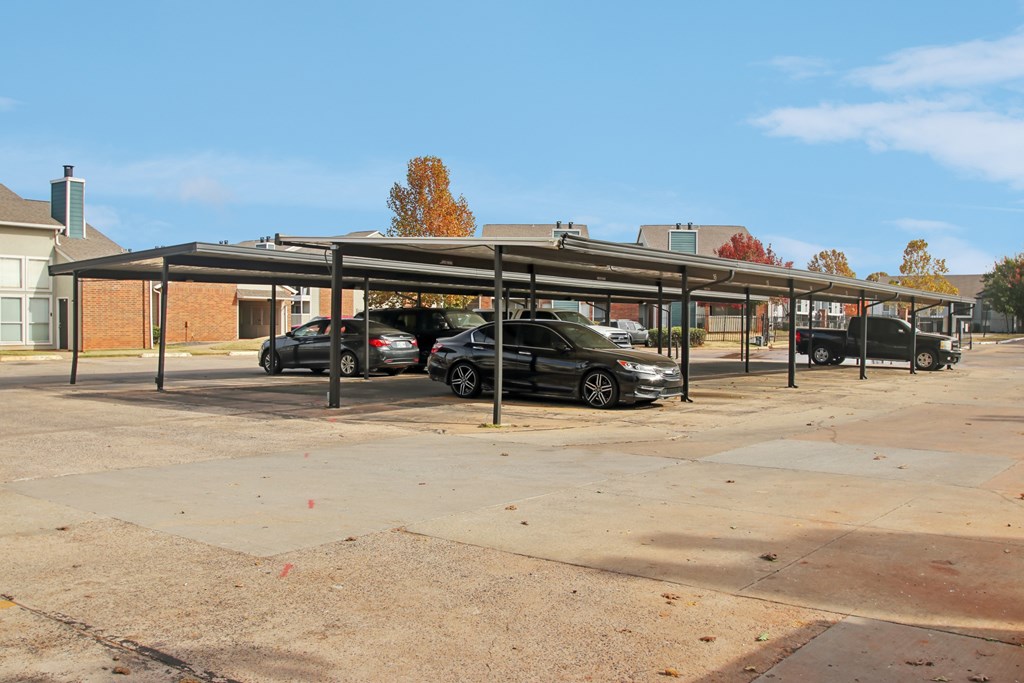 A parking lot with cars and a building in the background.