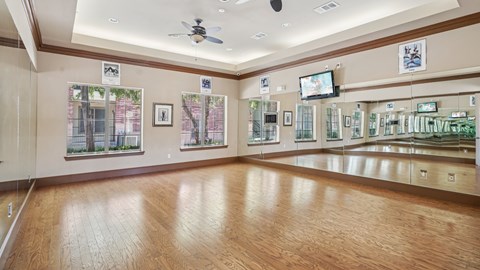 A room with wooden floors and a ceiling fan.