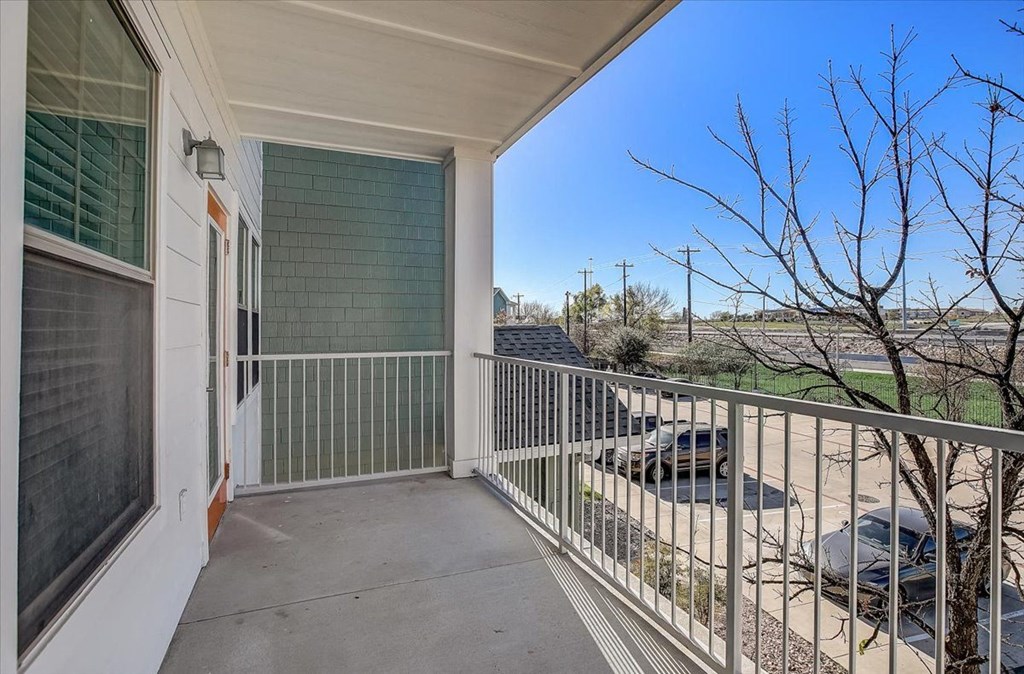 the view from the balcony of a home with a parking lot