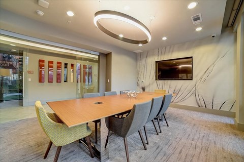 A conference room with a long table and chairs.