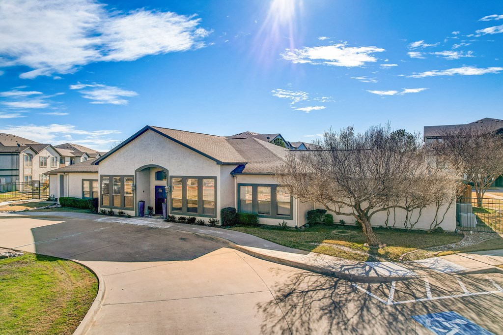 a house with a driveway and trees in front of it