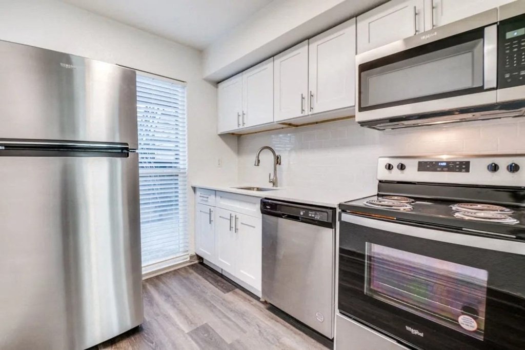 a kitchen with stainless steel appliances and white cabinets