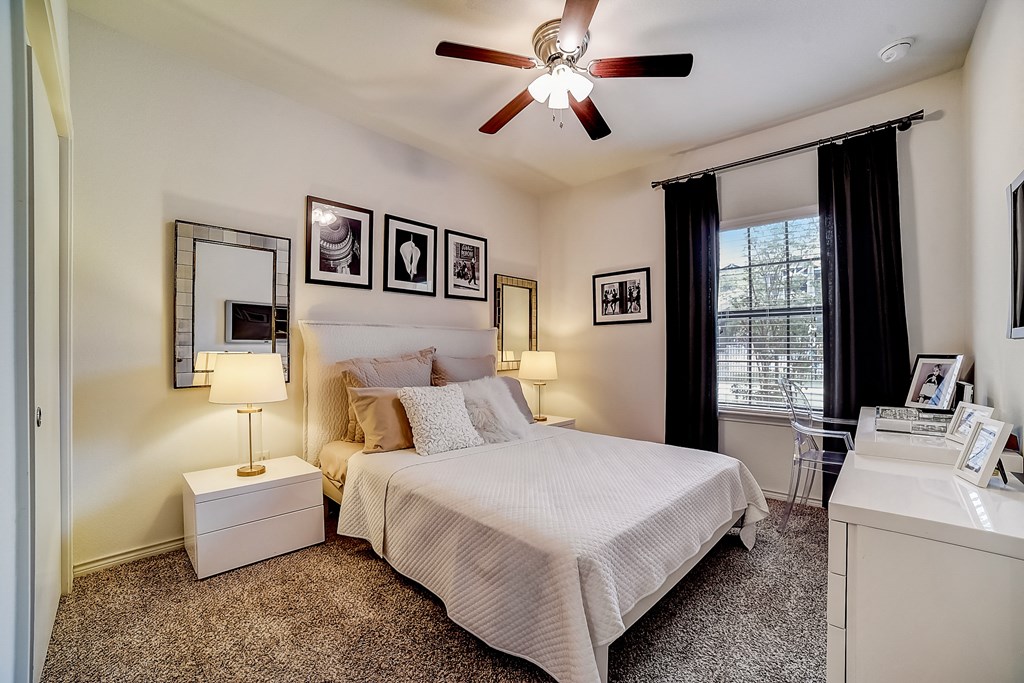 a bedroom with a large bed and a ceiling fan