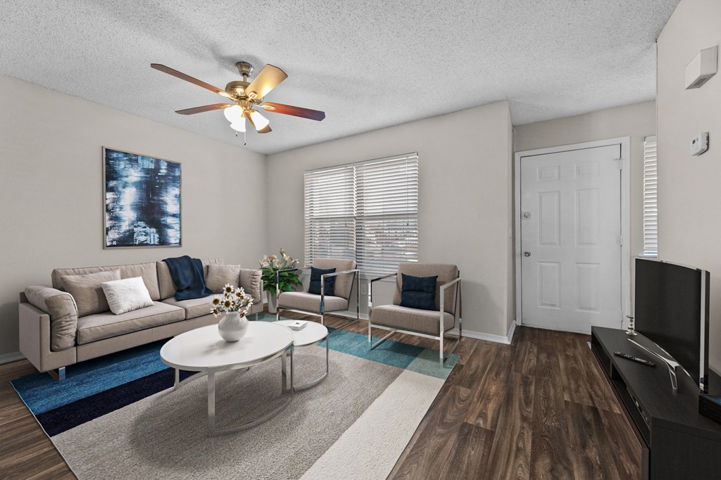 a living room with a ceiling fan and a tv