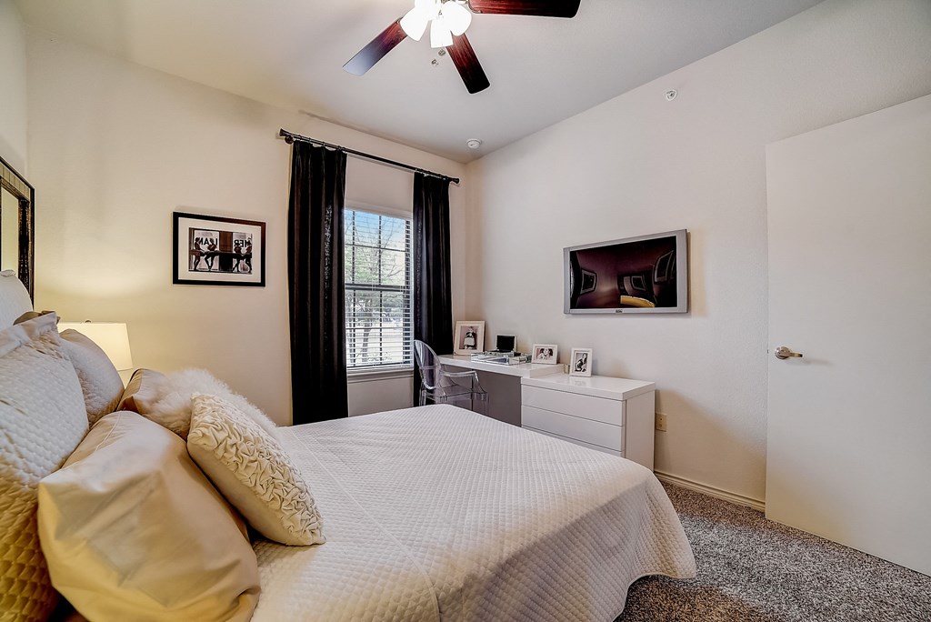 a bedroom with a large bed and a ceiling fan