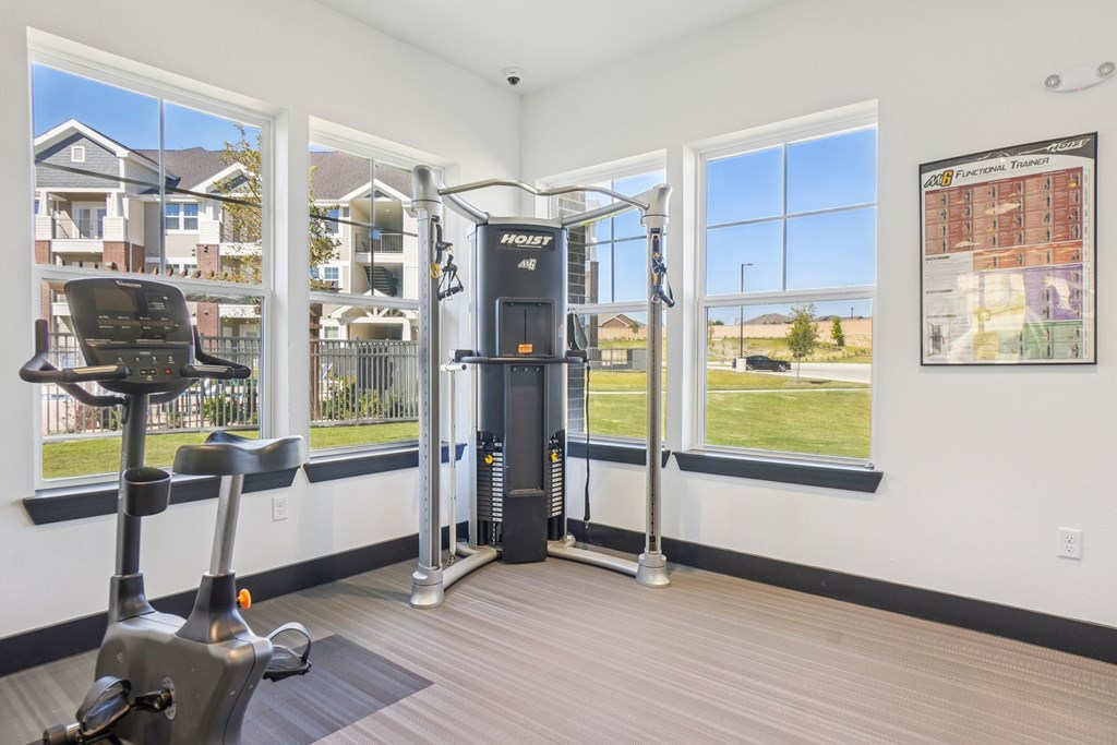 A home gym with a treadmill, a stationary bike and a weight machine.
