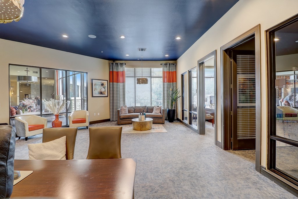 a living room with a blue ceiling and a table and chairs