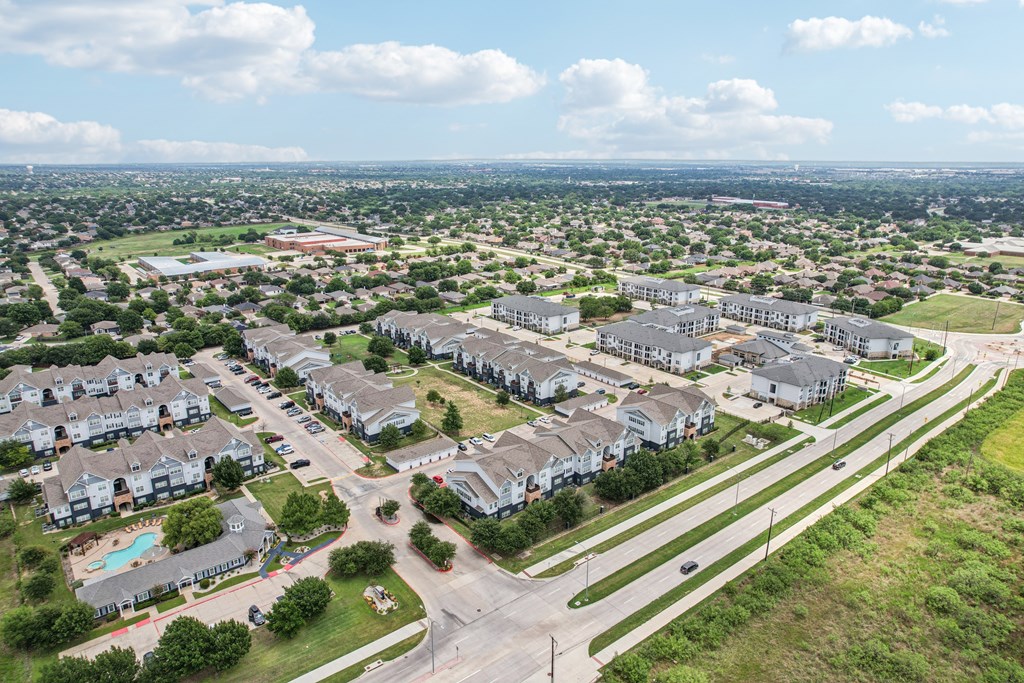 A suburban neighborhood with apartment buildings and a road with a median.