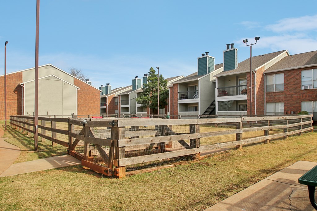 A row of apartment buildings with a wooden fence in front.
