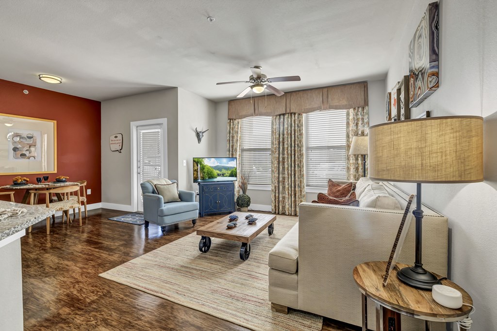 a living room with a couch and a table and a ceiling fan